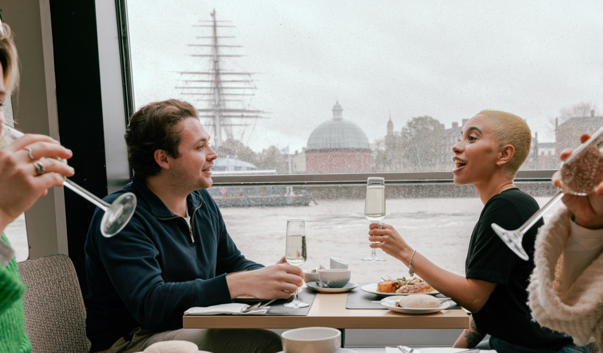 Couple enjoy afternoon tea on City Cruises boat in front of Cutty Sark